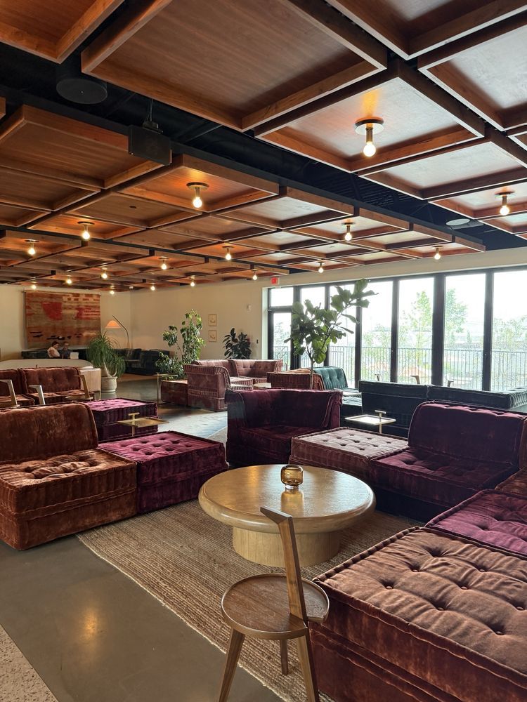 The lounge at Drift in Nashville: velvet sectionals, a coffered wood ceiling with bare bulbs and floor-to-ceiling windows