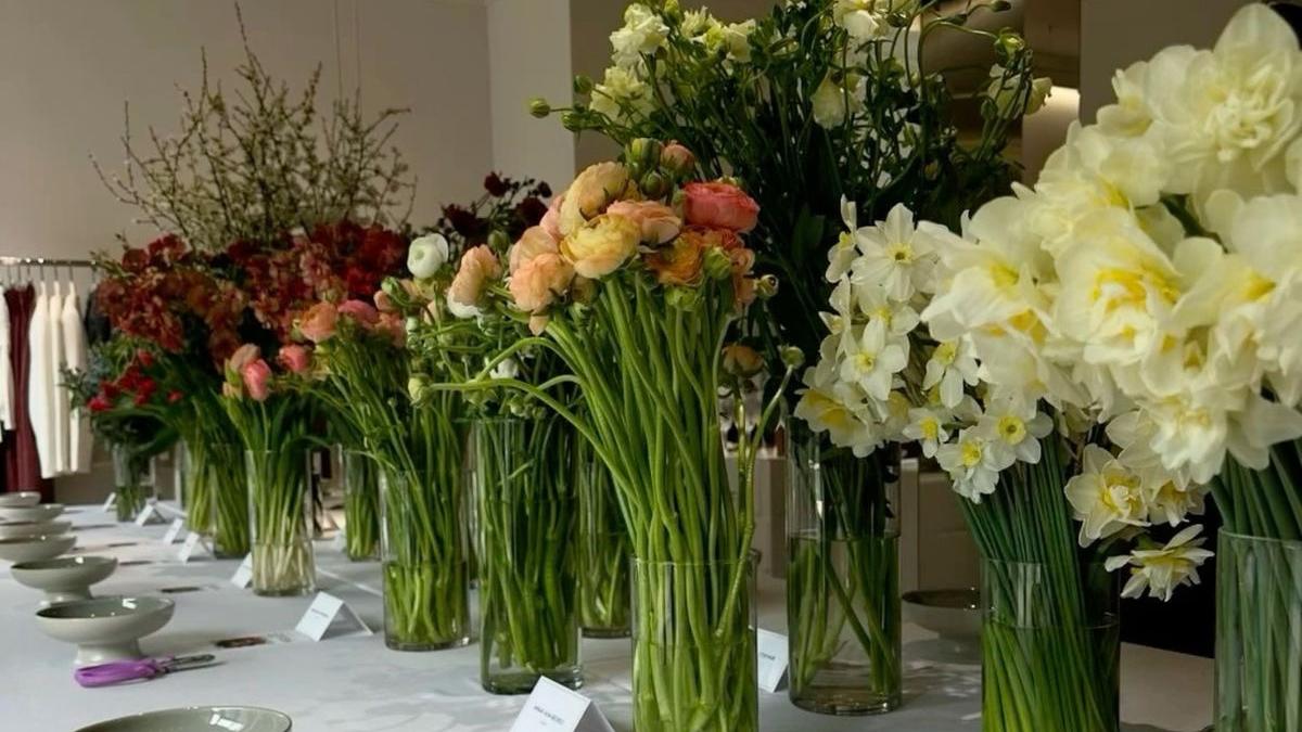 Long white tables lined with spring flowers in glass vases